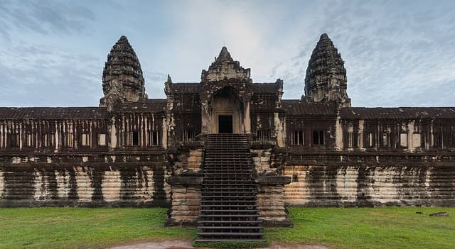 Angkor Vat, monument de Suryavarman II : Un vaste temple de pierre se reconnaît à ses cinq tours en forme de lotus, souvent reflétées dans les…