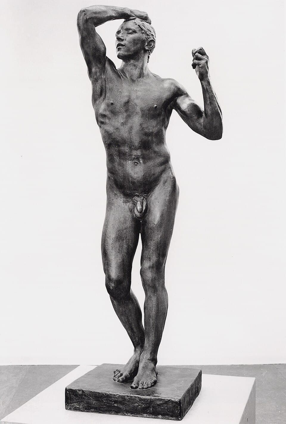 L’Âge d’airain, sculpture de Auguste Rodin : Un jeune homme nu se tient debout, le bras gauche levé vers la tête et la main droite posée…