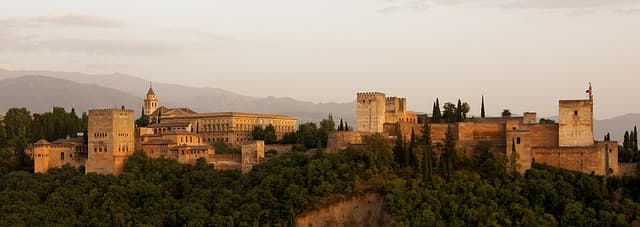 L’Alhambra, monument de Dynastie nasride : Des palais aux murs couverts d’arabesques entourent des cours avec bassins, colonnes fines et jardins…